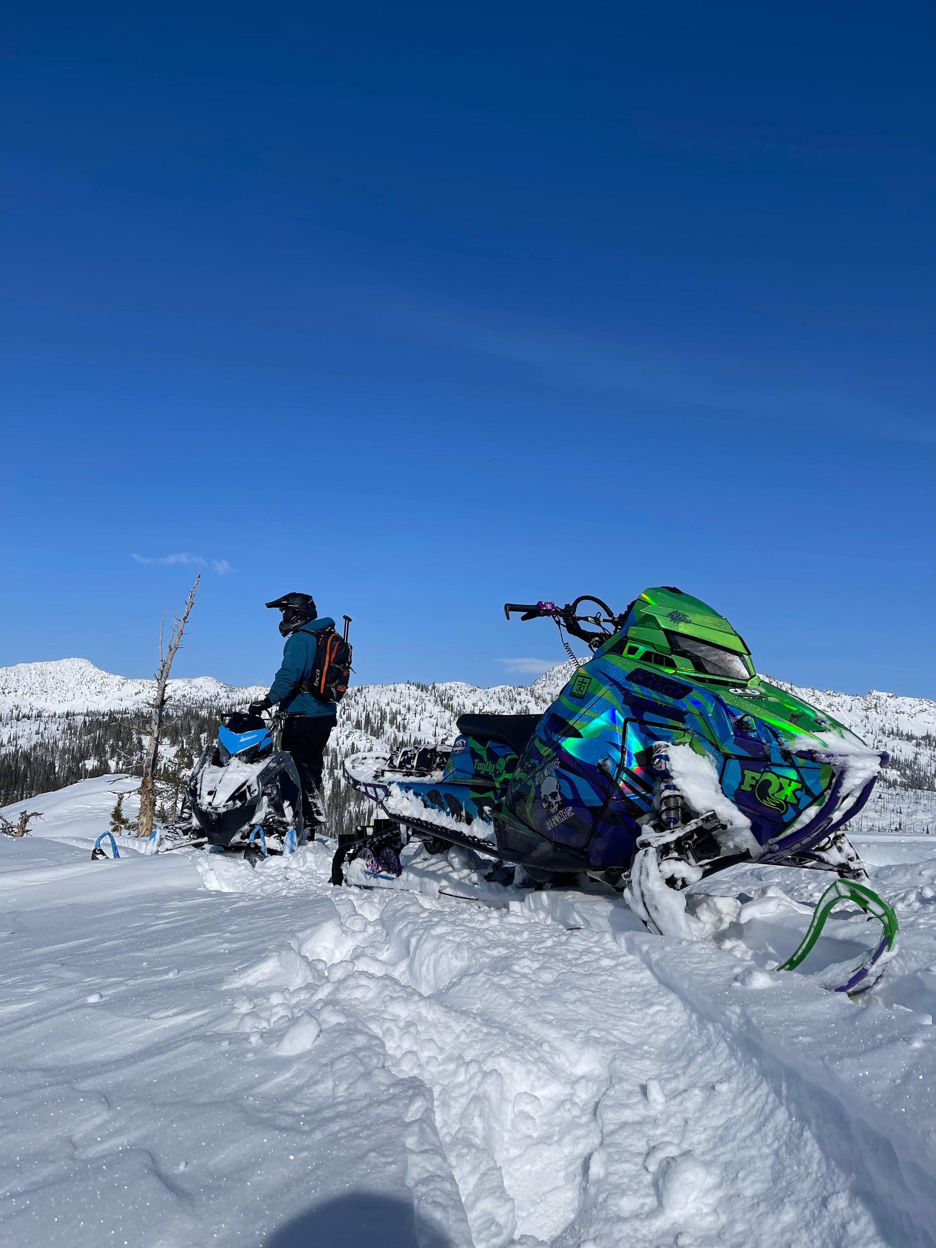 Snowmobile on a snowy mountain with clear blue sky