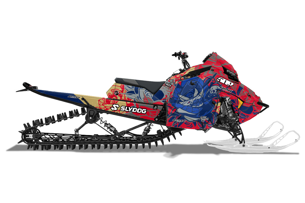 A side view of a Polaris snowmobile with a vibrant red, blue, and black graphic wrap, featuring the 'Slydog' brand name on the tunnel side, set against a plain white background.