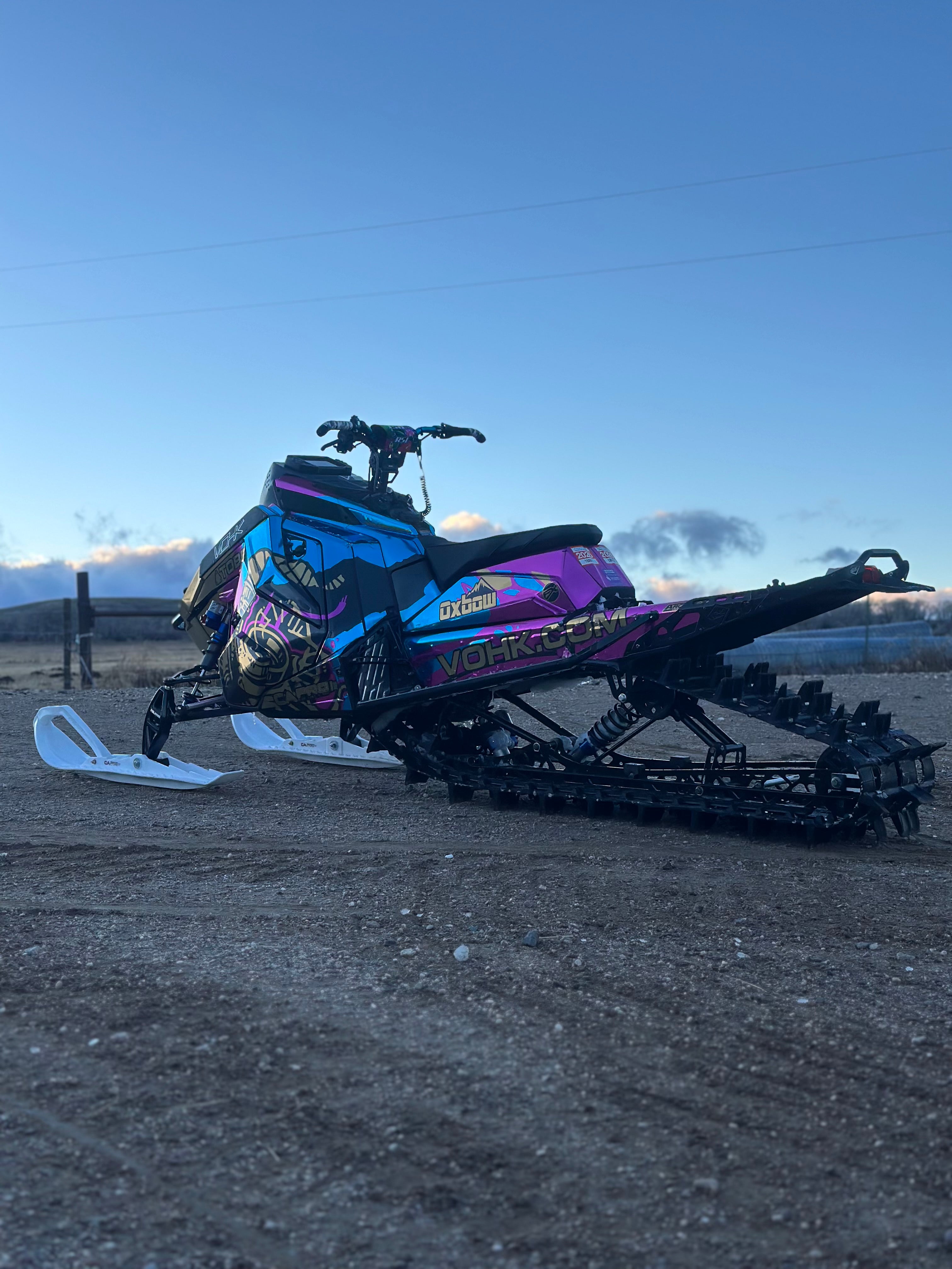 Colorful snowmobile on a dirt surface with a clear sky background
