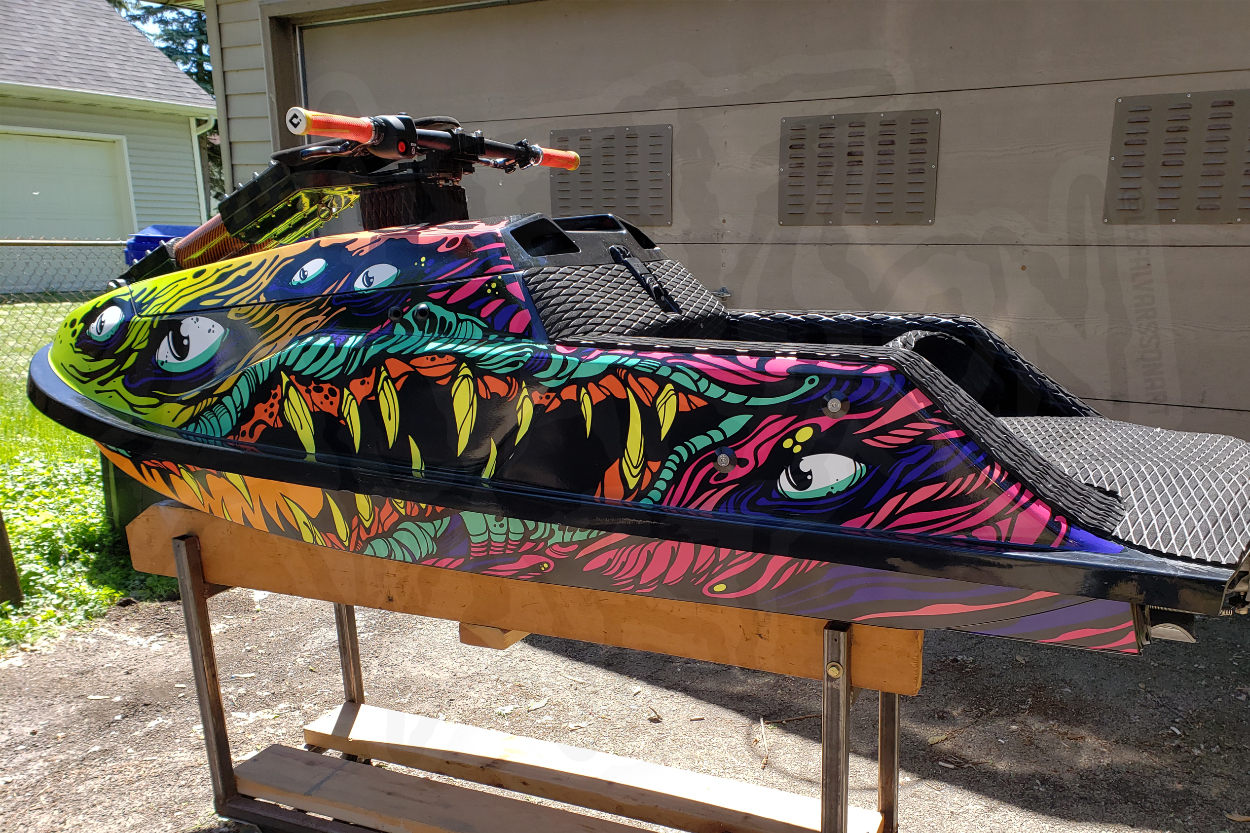 tiger craft jet ski with green purple orange colors with a sea creature graphics with sharp teeths